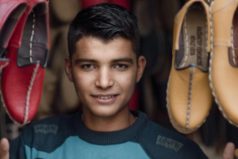 Image displays a headshot of one of our many loyal employees while shoes surround him.