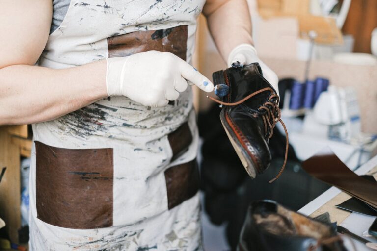 Image One, a man polishes the outer edge of the shoe's sole.