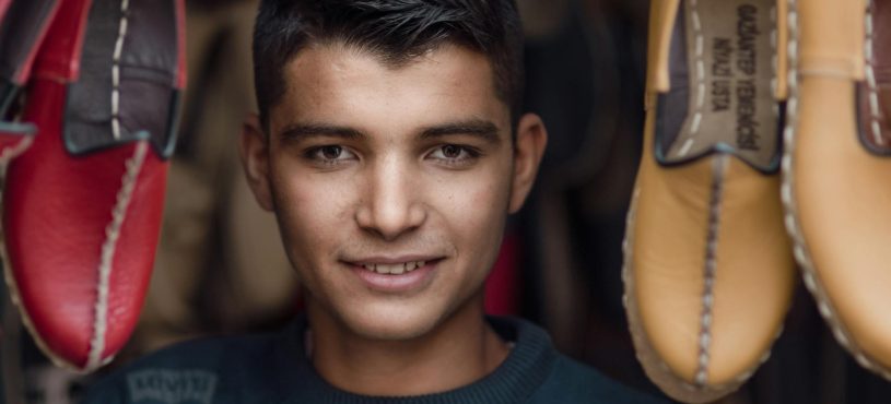 Image displays a headshot of one of our many loyal employees while shoes surround him.